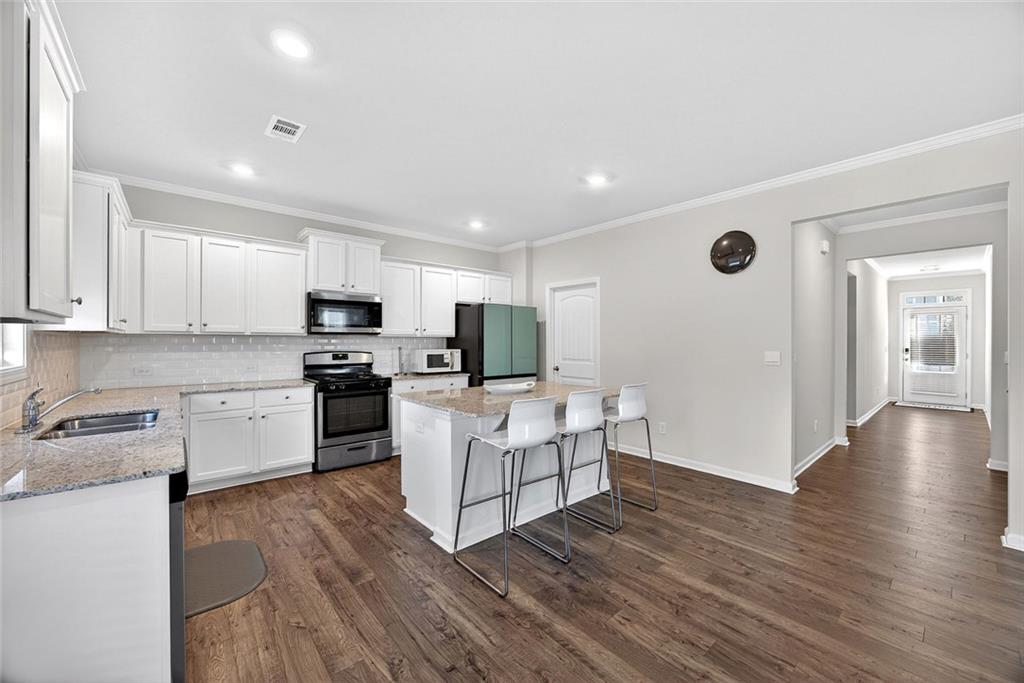 56 Berwick Crossing Dallas, GA 30157 - Photo 6 of 28 a kitchen with white cabinets and stainless steel appliances