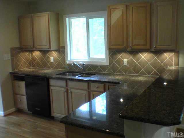 3608 Anclote Place Raleigh, NC 27607 - Photo 2 of 8 a kitchen with granite countertop wooden cabinets and a sink