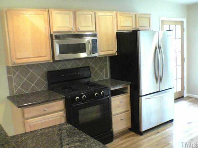 3608 Anclote Place Raleigh, NC 27607 - Photo 3 of 8 a kitchen with windows and a refrigerator