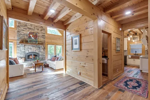 a living room with furniture large window and wooden floor
