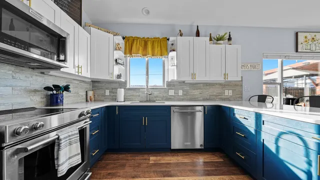 a kitchen with stainless steel appliances granite countertop a stove a sink and a microwave