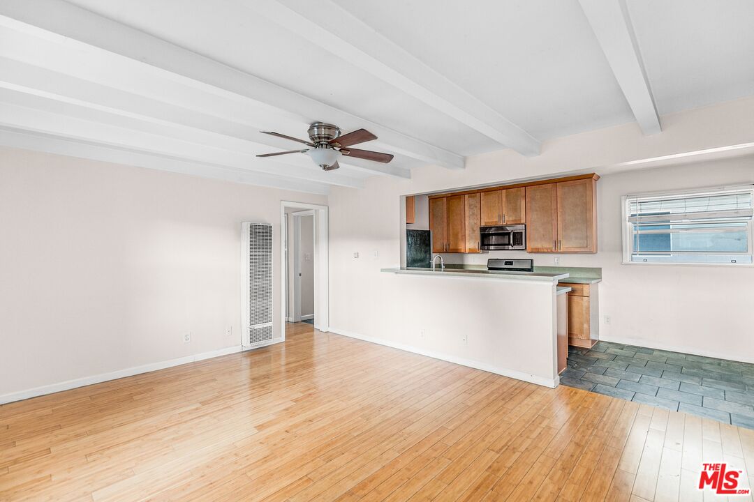 a view of empty room with wooden floor and window