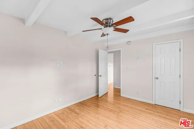 a view of a room with wooden floor and closet area