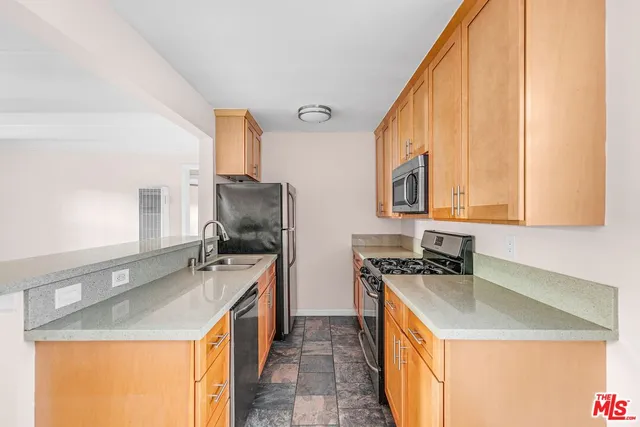 a kitchen with a sink stove top oven and cabinets
