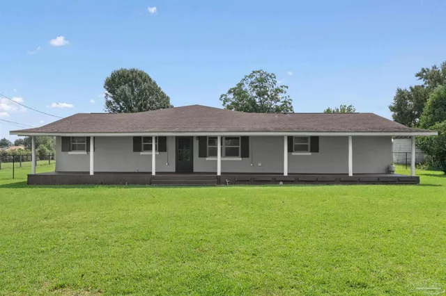 a view of a house with a yard and pathway