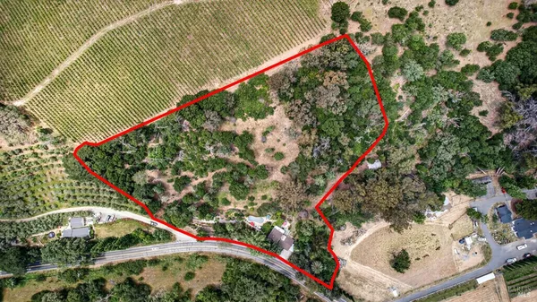 an aerial view of residential house with outdoor space and trees all around