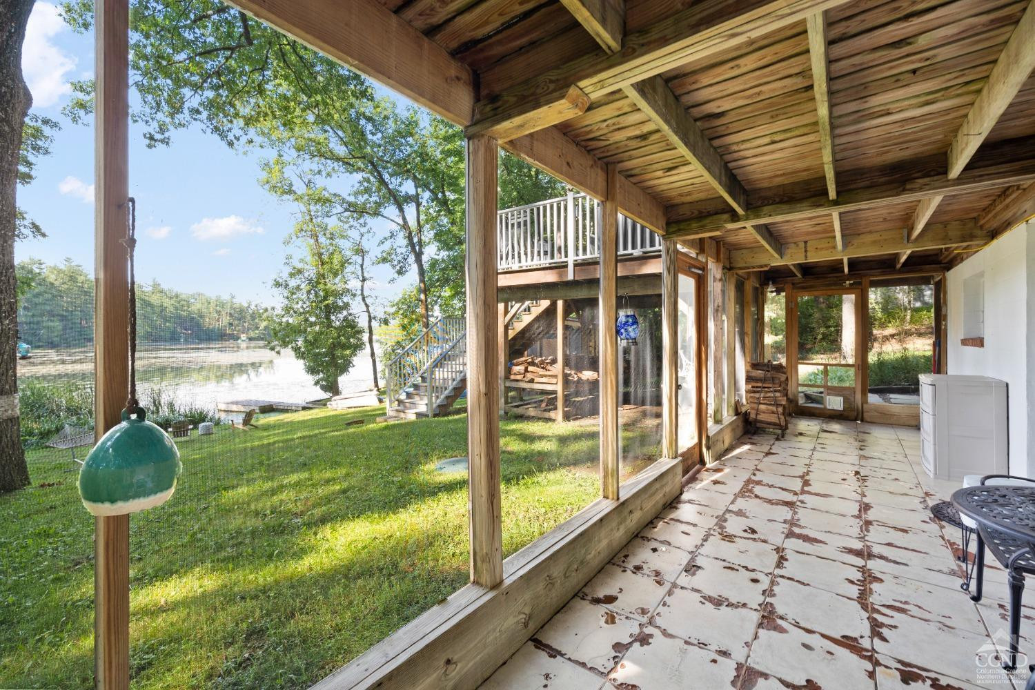 1264 Lakeview Road Copake, NY 12516 - Photo 5 of 24 a porch with a table chairs and wooden fence