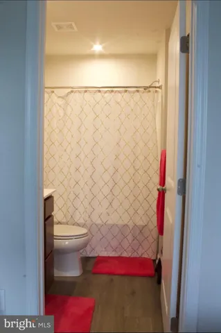 a bathroom with a toilet and a shower curtain