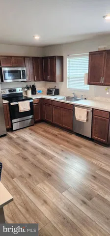 a kitchen with stainless steel appliances kitchen island granite countertop a stove a sink and a microwave