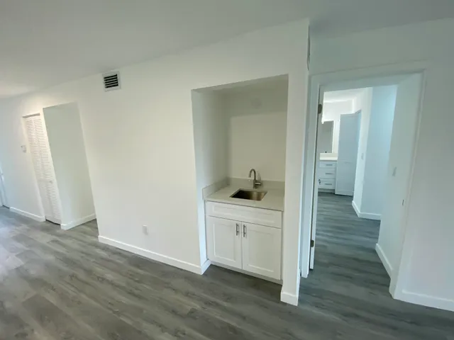 a view of a hallway with wooden floor and a sink