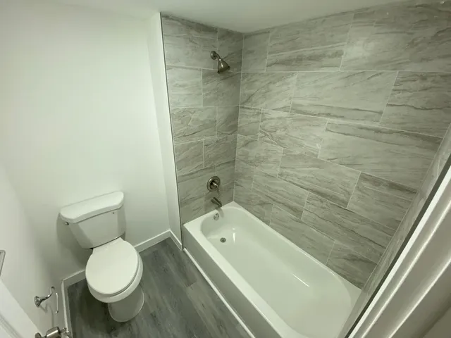 a bathroom with a granite countertop toilet a sink and bathtub