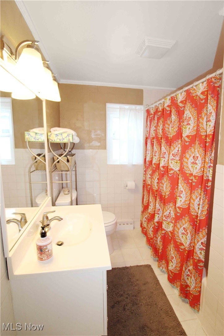 2708 East Sand Road Port Clinton, OH 43452 - Photo 24 of 33 Bathroom featuring vanity, tile walls, and a wealth of natural light