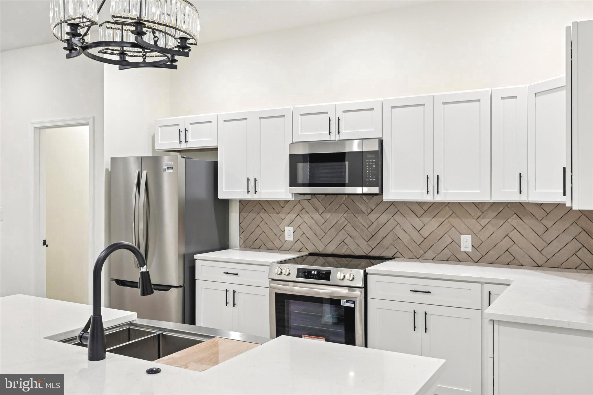 1326 North Frazier Street Philadelphia, PA 19131 - Photo 12 of 40 a kitchen with stainless steel appliances granite countertop a sink a stove and refrigerator