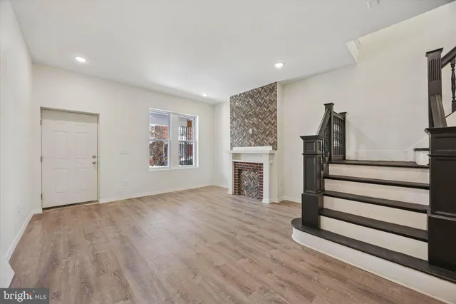 a view of empty room with wooden floor and fireplace