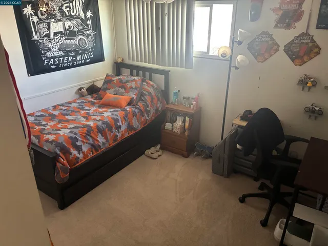 a bed sitting in a bedroom next to a window