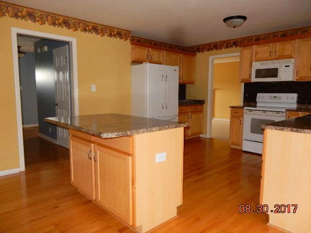 261 7 Mile Ferry Road Cunningham, TN 37052 - Photo 5 of 24 a kitchen with stainless steel appliances granite countertop a refrigerator a stove and a microwave with wooden floor