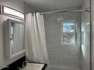 a bathroom with a shower and a sink