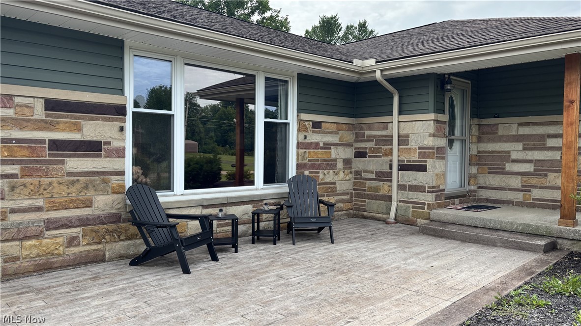 11784 Chamberlain Road Mantua, OH 44255 - Photo 36 of 50 Exterior facade featuring stone veneer, horizontal siding, and a covered porch