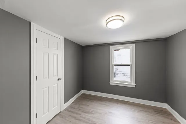 an empty room with windows and closet