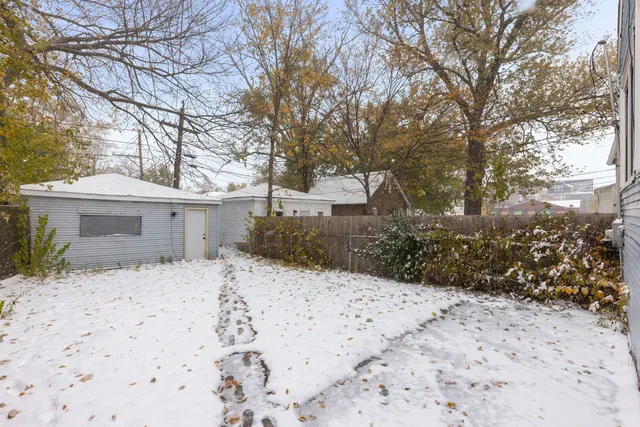 a front view of a house with a yard covered with snow
