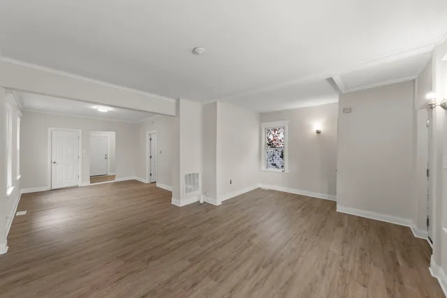 a view of an empty room with wooden floor