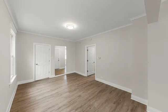 a view of an empty room with wooden floor