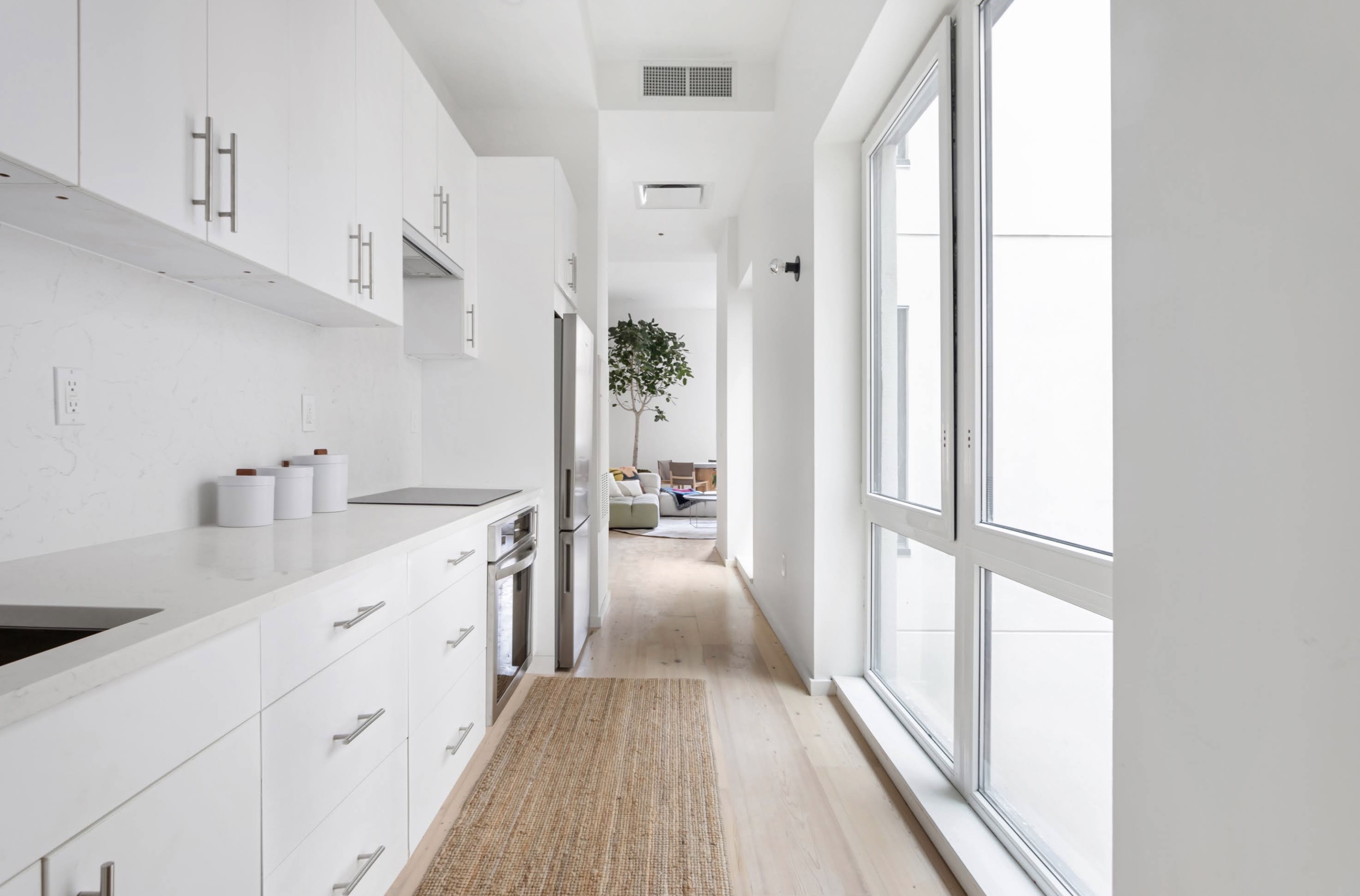 a hallway with white cabinets and wooden floor