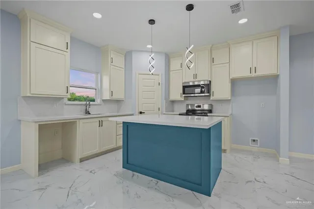 a large kitchen with stainless steel appliances a sink stove and cabinets