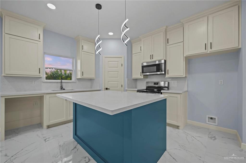 994 Rd Runner Street Rio Grande City, TX 78582 - Photo 6 of 17 a kitchen with kitchen island granite countertop a sink a counter top space appliances and cabinets