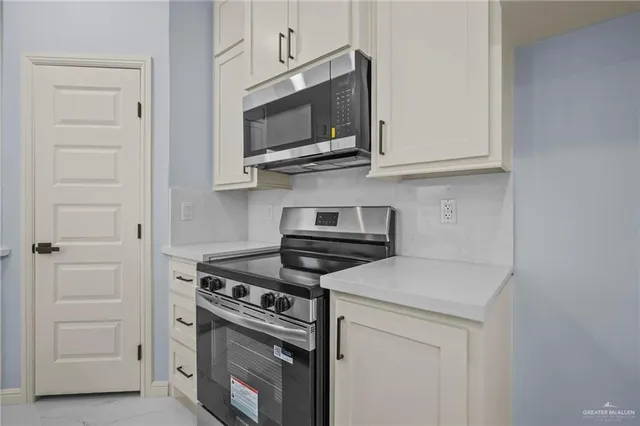 a kitchen with kitchen island granite countertop a sink a counter top space appliances and cabinets