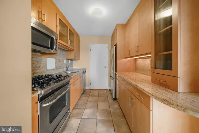 a kitchen with stainless steel appliances granite countertop a stove and a refrigerator