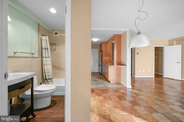 a view of a bathroom with toilet window and wooden floor