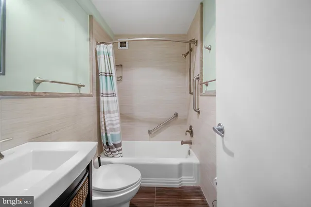 a bathroom with a bathtub shower sink mirror vanity and toilet