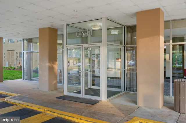 a living room with a bed and glass door