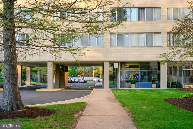 a front view of a building with a garden and plants
