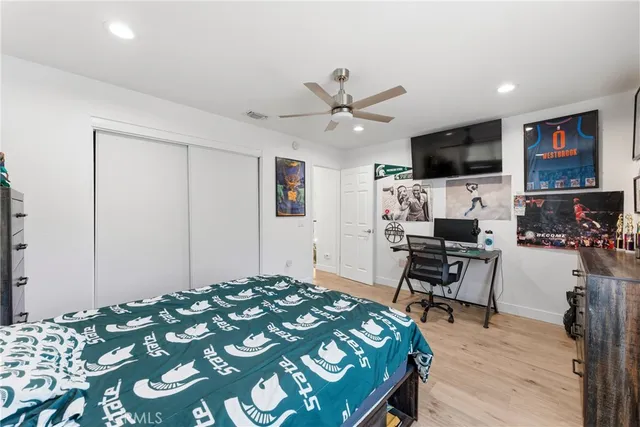 a bedroom with a bed and a flat screen tv