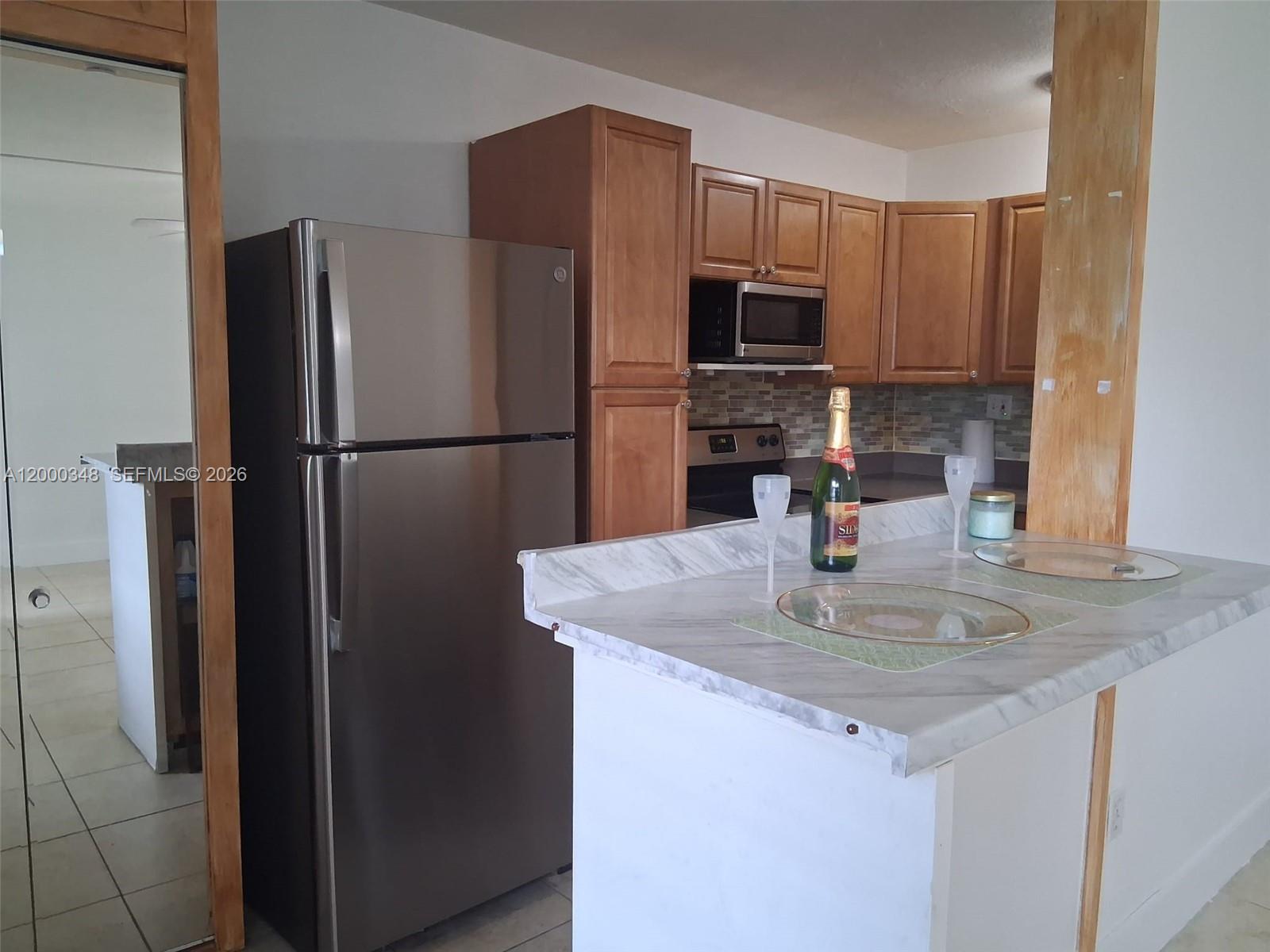 4444 Southwest 67th Avenue, Unit 6 Miami, FL 33155 - Photo 4 of 11 a kitchen with refrigerator a microwave a sink and cabinets