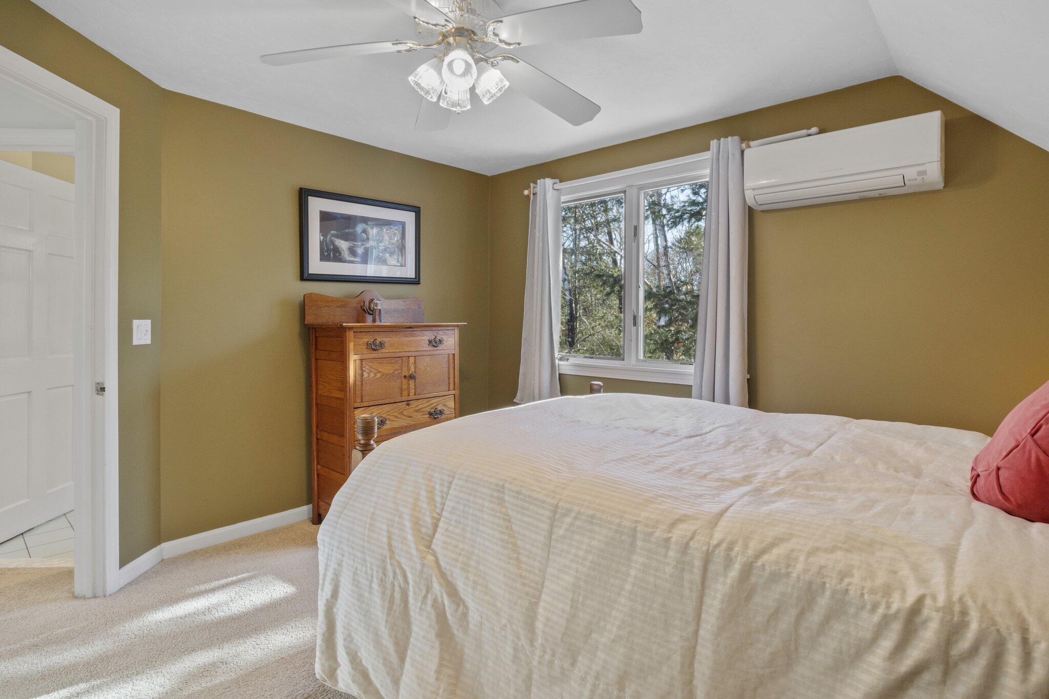 244 Santuit Road Cotuit, MA 02635 - Photo 40 of 58 a bedroom with a large bed and a chandelier