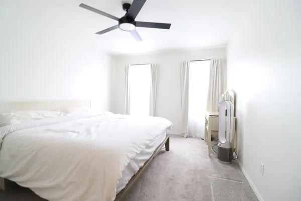 a spacious bedroom with a bed and a ceiling fan
