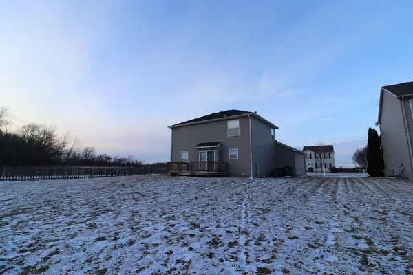 a view of a grey house with a yard