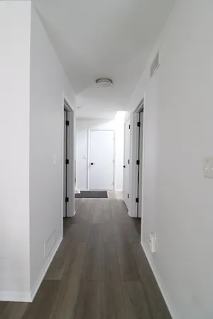 a view of a hallway with wooden floor and a closet