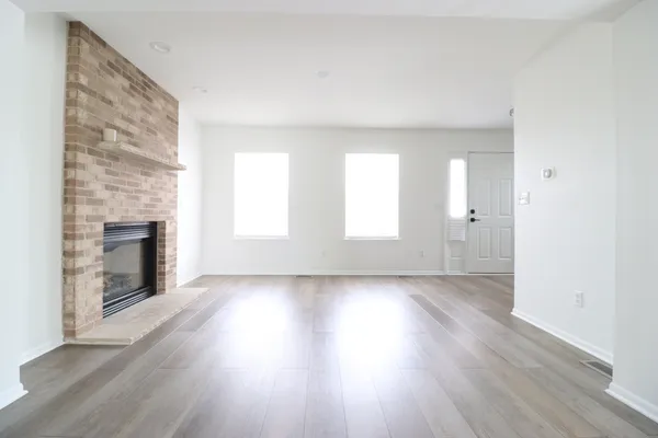 an empty room with wooden floor and fireplace