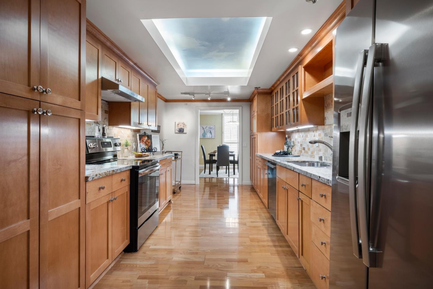 110 Park Road, Unit 103 Burlingame, CA 94010 - Photo 15 of 48 a kitchen with stainless steel appliances granite countertop a refrigerator a oven a sink with wooden floors and cabinets