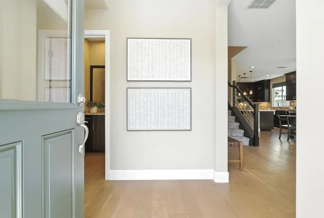 a view of a hallway with wooden floor windows and a kitchen