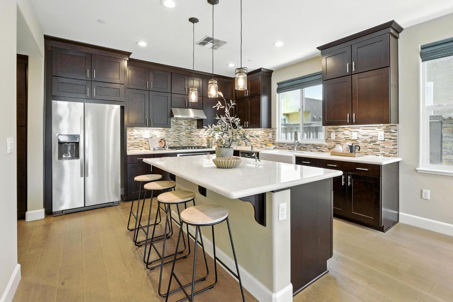2248 Cannery Loop Davis, CA 95616 - Photo 9 of 34 a kitchen with stainless steel appliances kitchen island granite countertop a sink a refrigerator and a refrigerator