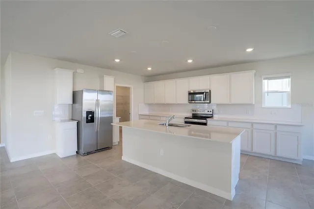 a kitchen with refrigerator a sink and cabinets
