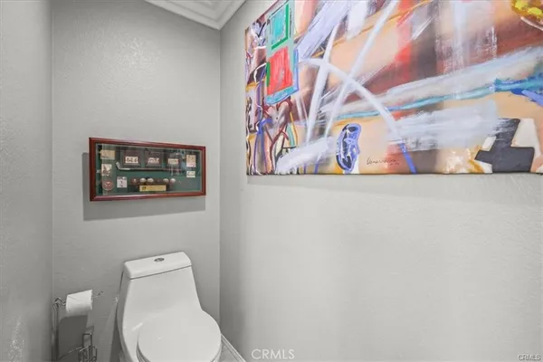 a white toilet sitting next to a white wall