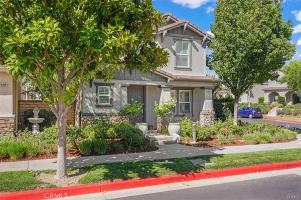a front view of a house with a garden and plants