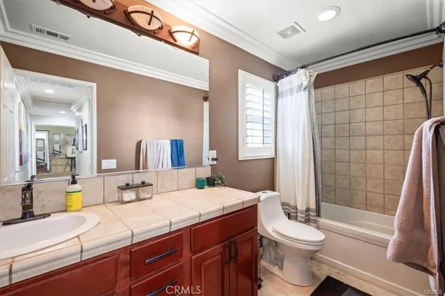 a bathroom with a double vanity sink toilet and shower