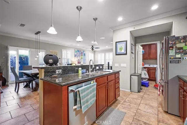 a kitchen with stainless steel appliances granite countertop a sink a stove and a wooden cabinets